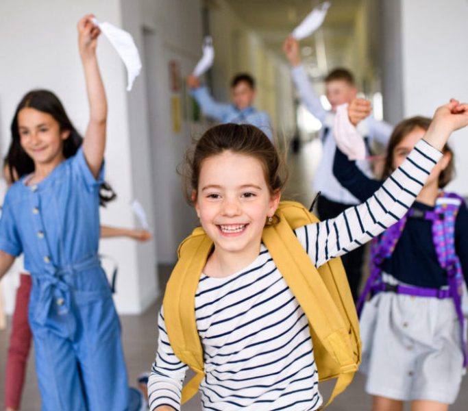 Group of cheerful children going home from school after covid-19 quarantine and lockdown. Group of cheerful children going home from school after covid-19 quarantine and lockdown, taking off face masks.