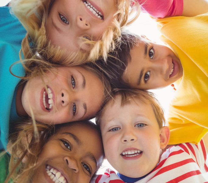 Smiling classmates with arms around looking down to camera 576659